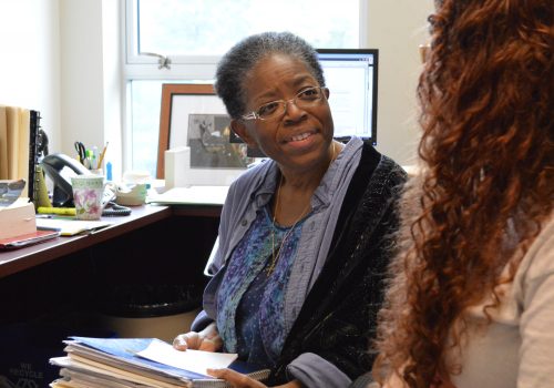Dee James sitting with a student in her office