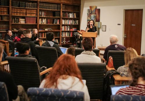 Author Crystal Hana Kim reading at a podium.